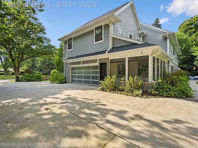 295 S Cranbrook Rd, Birmingham, MI 48009 - view of side of property with driveway, covered porch, a garage, brick siding, and roof with shingles