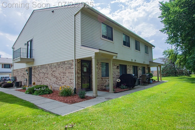 50191 N Angelo Ct, Chesterfield, MI 48047 - view of side of home with a balcony, brick siding, a lawn, and a patio