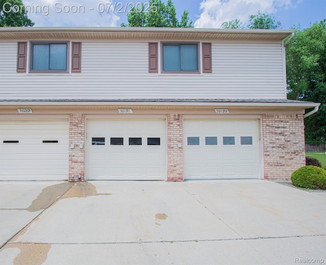 50191 N Angelo Ct, Chesterfield, MI 48047 - view of front of house featuring driveway, a garage, and brick siding