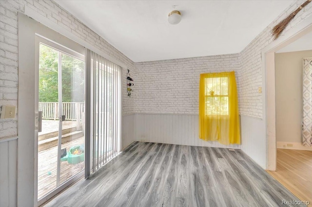 1232 N Saginaw St, Lapeer, MI 48446 - spare room featuring wood finished floors and brick wall