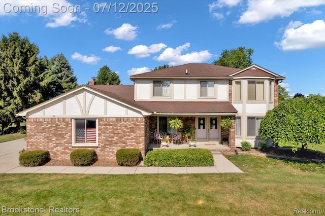 46655 Spruce Dr, Shelby Twp, MI 48315 - view of front of property with a front yard, a porch, and brick siding