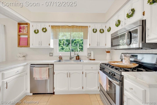 46655 Spruce Dr, Shelby Twp, MI 48315 - kitchen featuring appliances with stainless steel finishes, light tile patterned floors, white cabinets, and light countertops