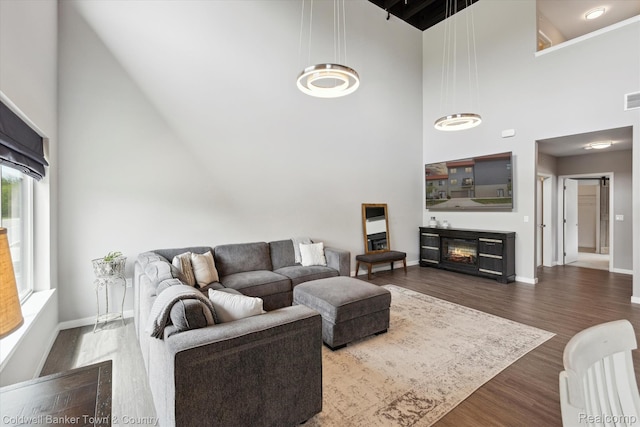 293 N 2nd St Unit 106, Brighton, MI 48116 - living area with a towering ceiling, dark wood finished floors, and a glass covered fireplace