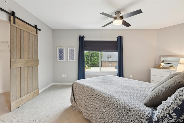 293 N 2nd St Unit 106, Brighton, MI 48116 - bedroom with a barn door, light carpet, and a ceiling fan