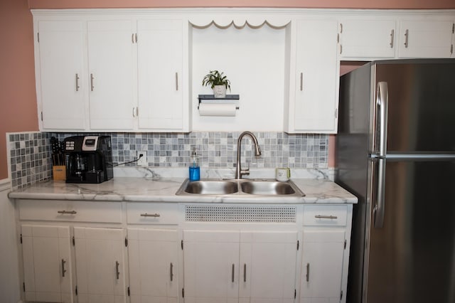 516 Cooper Ave, Kalamazoo, MI 49048 - kitchen with freestanding refrigerator, white cabinetry, and tasteful backsplash