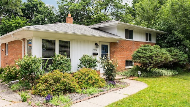 2204 Walter Dr, Ann Arbor, MI 48103 - view of front facade featuring brick siding, a shingled roof, a chimney, and a front lawn