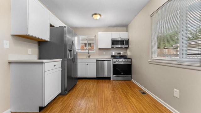 2204 Walter Dr, Ann Arbor, MI 48103 - kitchen featuring appliances with stainless steel finishes, white cabinets, and healthy amount of natural light