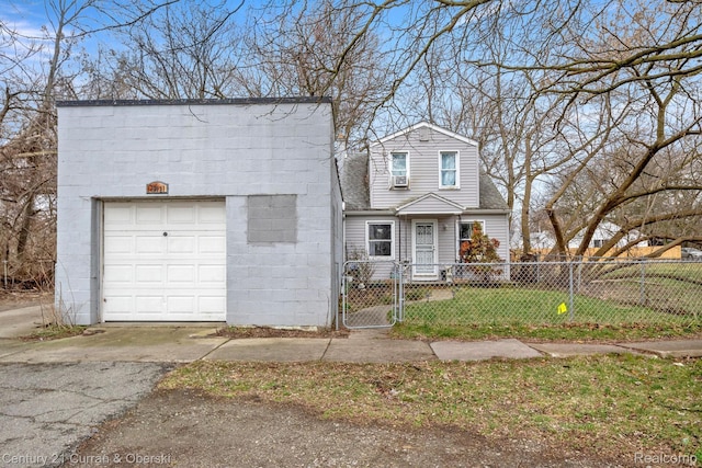25021 Ecorse Rd, Taylor, MI 48180 - view of front of house with a fenced front yard, a garage, concrete block siding, driveway, and a gate