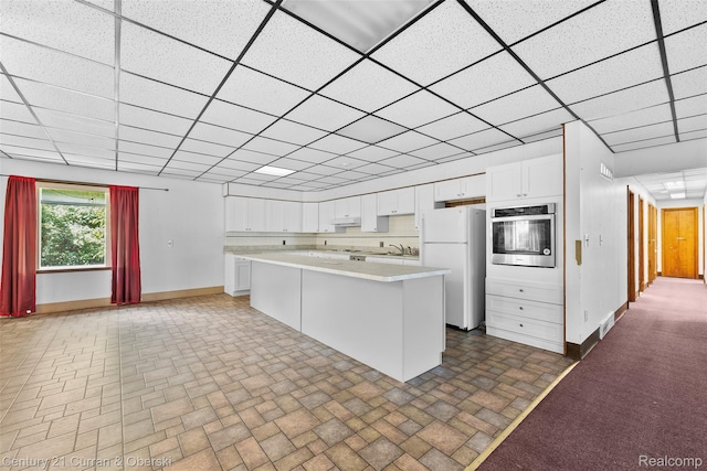 5620 Kaufman St, Dearborn Heights, MI 48125 - kitchen featuring freestanding refrigerator, stainless steel oven, light countertops, brick patterned floors, and white cabinets