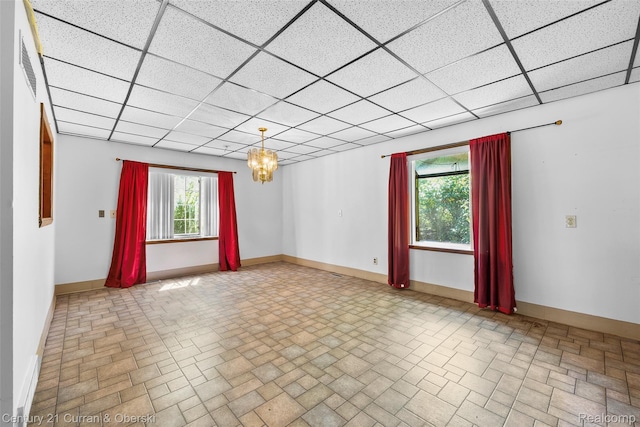 5620 Kaufman St, Dearborn Heights, MI 48125 - empty room with brick patterned flooring, a paneled ceiling, and a chandelier