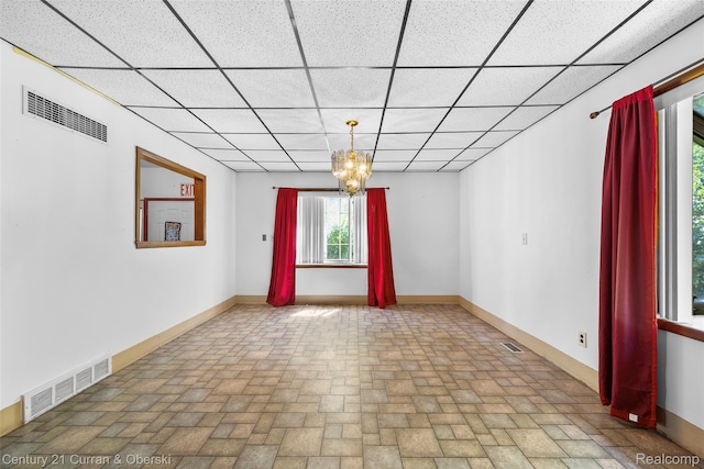 5620 Kaufman St, Dearborn Heights, MI 48125 - unfurnished room featuring brick patterned flooring, a paneled ceiling, and a chandelier