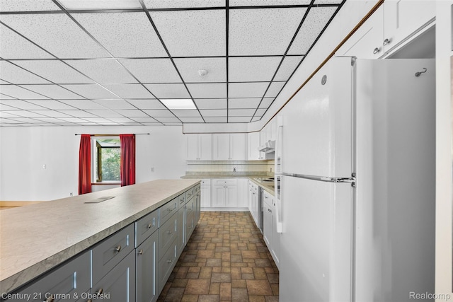 5620 Kaufman St, Dearborn Heights, MI 48125 - kitchen with white appliances, gray cabinets, white cabinetry, under cabinet range hood, and light countertops