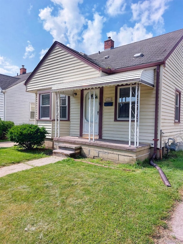 14535 Russell Ave, Allen Park, MI 48101 - bungalow featuring a front yard, covered porch, and a chimney
