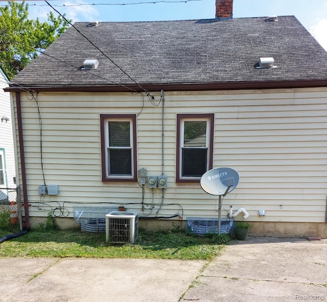 14535 Russell Ave, Allen Park, MI 48101 - view of property exterior featuring roof with shingles, a chimney, and a patio