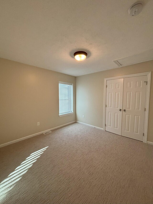 436 Martin Luther King Jr St SE, Grand Rapids, MI 49507 - unfurnished bedroom with carpet, a closet, and a textured ceiling