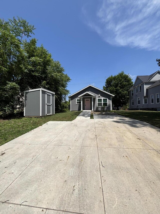 436 Martin Luther King Jr St SE, Grand Rapids, MI 49507 - view of front of property featuring concrete driveway, a storage shed, and a front lawn