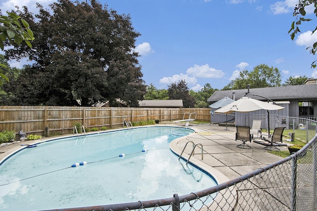 6245 Woodlea Dr, Kalamazoo, MI 49048 - view of pool with a fenced backyard, a patio, and a diving board