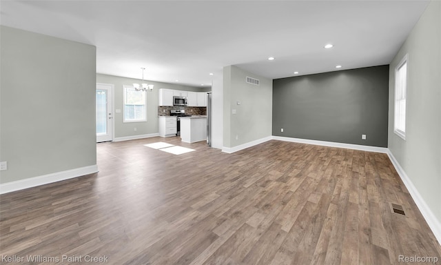 23858 Vassar Ave, Hazel Park, MI 48030 - unfurnished living room featuring a chandelier, wood finished floors, and recessed lighting