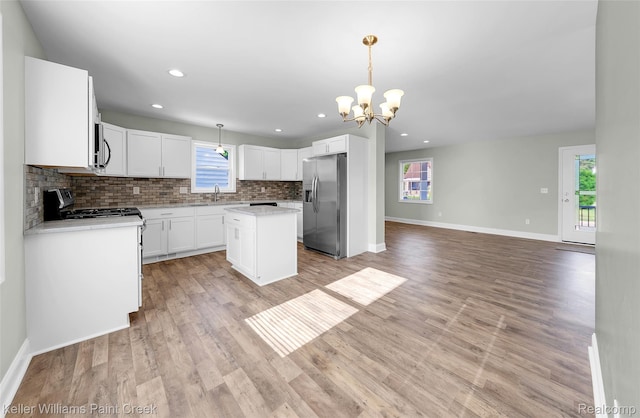 23858 Vassar Ave, Hazel Park, MI 48030 - kitchen featuring appliances with stainless steel finishes, backsplash, a kitchen island, a chandelier, and light countertops