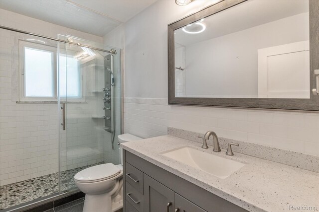 7262 Hatchery Rd, Waterford, MI 48327 - bathroom featuring tile walls, vanity, a shower stall, and wainscoting