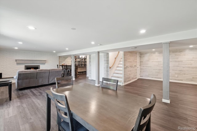 7262 Hatchery Rd, Waterford, MI 48327 - dining space with a fireplace, stairway, wood finished floors, recessed lighting, and brick wall