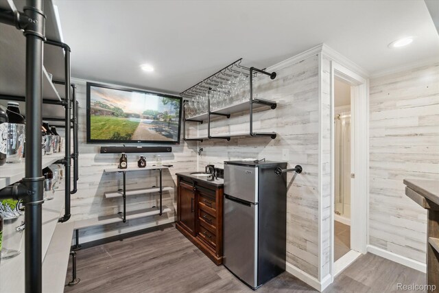 7262 Hatchery Rd, Waterford, MI 48327 - indoor bar with freestanding refrigerator, dark wood-style flooring, wooden walls, recessed lighting, and ornamental molding