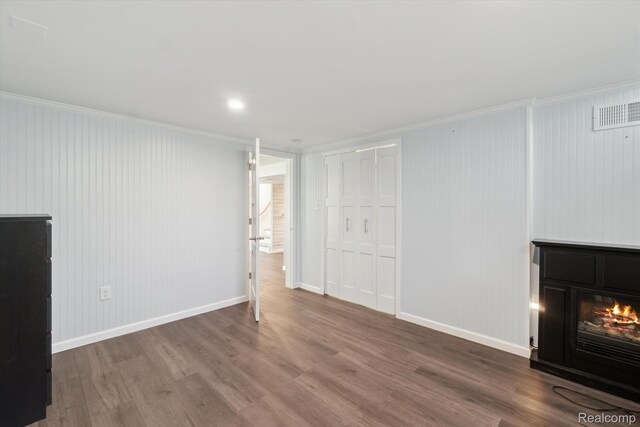 7262 Hatchery Rd, Waterford, MI 48327 - unfurnished living room with a glass covered fireplace, wood finished floors, and crown molding