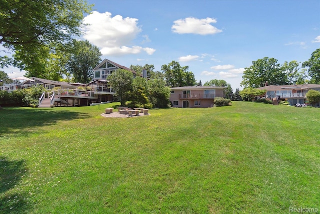 7262 Hatchery Rd, Waterford, MI 48327 - view of green lawn with a fire pit, a wooden deck, and stairs