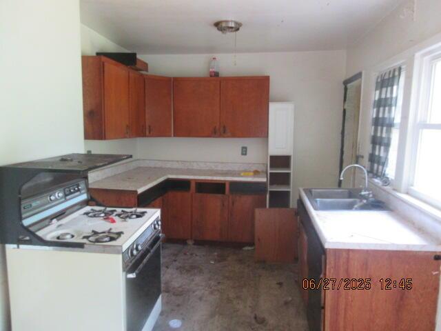 84 Somerset Ave, Battle Creek, MI 49037 - kitchen with gas range gas stove, brown cabinetry, and light countertops