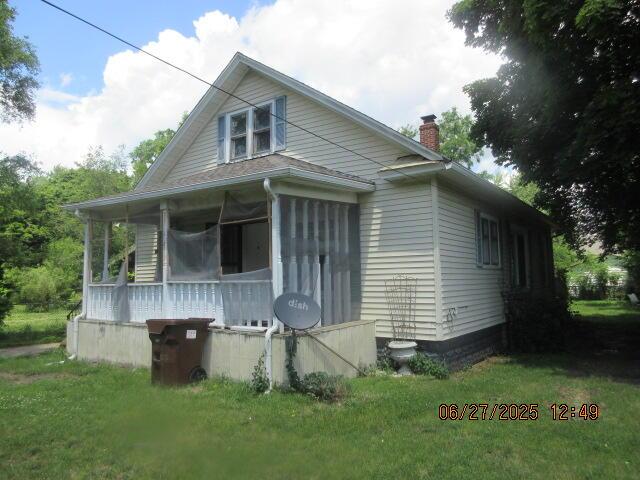 84 Somerset Ave, Battle Creek, MI 49037 - bungalow-style home with a chimney and a front lawn