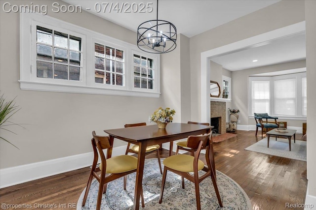 3801 Vicksburg St, Detroit, MI 48206 - dining area with a chandelier, dark wood finished floors, and a brick fireplace