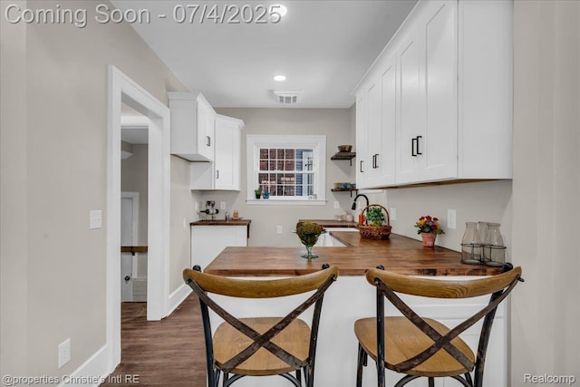 3801 Vicksburg St, Detroit, MI 48206 - kitchen featuring white cabinetry, dark wood-type flooring, open shelves, and a kitchen bar
