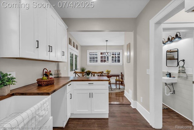 3801 Vicksburg St, Detroit, MI 48206 - kitchen with butcher block counters, dark wood-type flooring, white cabinetry, a chandelier, and a peninsula