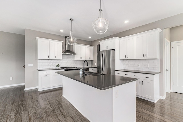 4047 Enclave Way Unit 1, Kalamazoo, MI 49006 - kitchen with freestanding refrigerator, dark countertops, wall chimney exhaust hood, dark wood-style floors, and a center island with sink