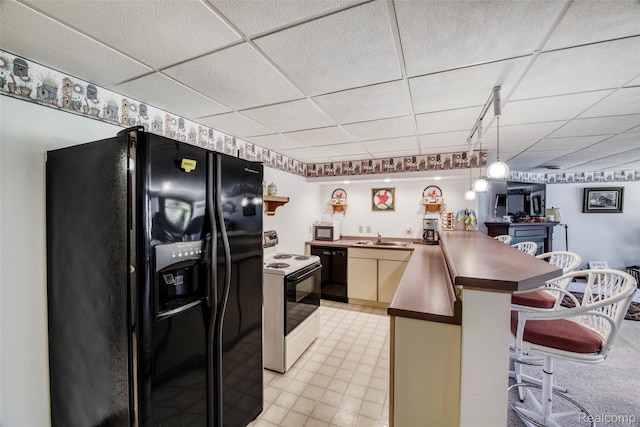 24559 S Klingville Rd, Chassell, MI 49916 - kitchen with black appliances, a kitchen breakfast bar, a drop ceiling, a peninsula, and pendant lighting