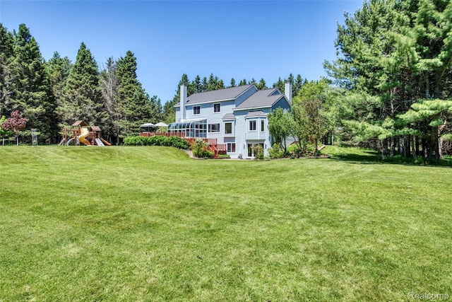24559 S Klingville Rd, Chassell, MI 49916 - back of house with a chimney, a playground, and a lawn