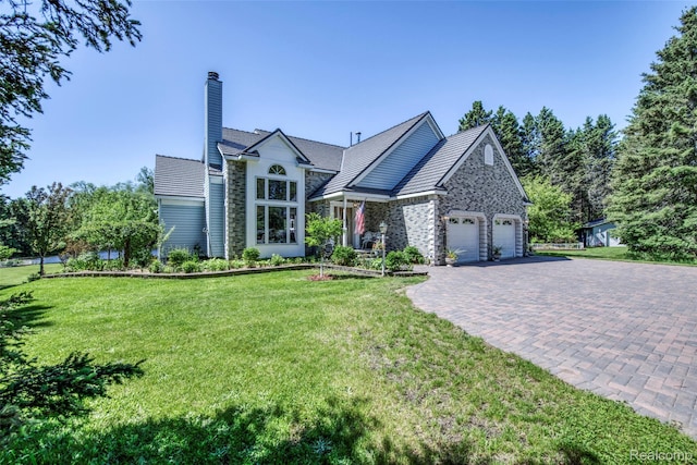 24559 S Klingville Rd, Chassell, MI 49916 - view of front of property with a front yard, a garage, decorative driveway, stone siding, and a chimney