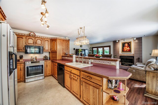 24559 S Klingville Rd, Chassell, MI 49916 - kitchen featuring black appliances, open floor plan, a peninsula, dark countertops, and brown cabinetry