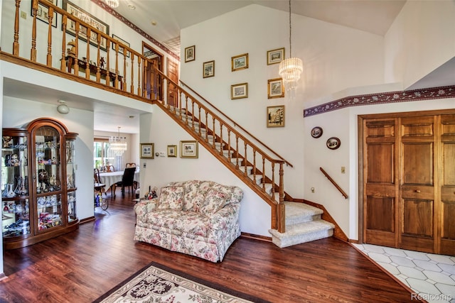 24559 S Klingville Rd, Chassell, MI 49916 - living area featuring a chandelier, wood finished floors, stairway, and high vaulted ceiling