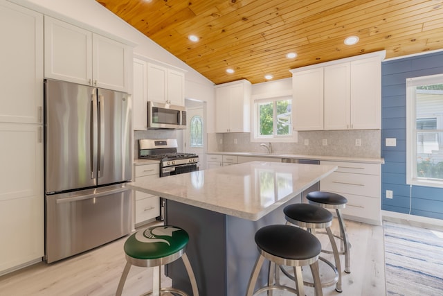22770 Oak St, Pierson, MI 49339 - kitchen featuring appliances with stainless steel finishes, wooden ceiling, vaulted ceiling, a kitchen breakfast bar, and light wood-style floors
