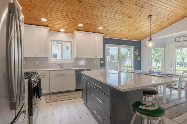 22770 Oak St, Pierson, MI 49339 - kitchen with stainless steel appliances, wood ceiling, a kitchen breakfast bar, light wood-type flooring, and white cabinetry