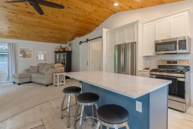 22770 Oak St, Pierson, MI 49339 - kitchen with appliances with stainless steel finishes, lofted ceiling, wooden ceiling, a barn door, and white cabinets