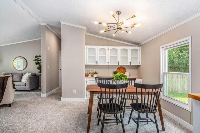 713 Maple Rd, Ionia, MI 48846 - dining space with a chandelier, lofted ceiling, light carpet, a textured ceiling, and ornamental molding