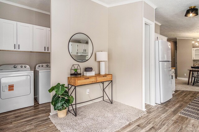 713 Maple Rd, Ionia, MI 48846 - laundry room featuring separate washer and dryer, cabinet space, wood finished floors, a textured ceiling, and crown molding