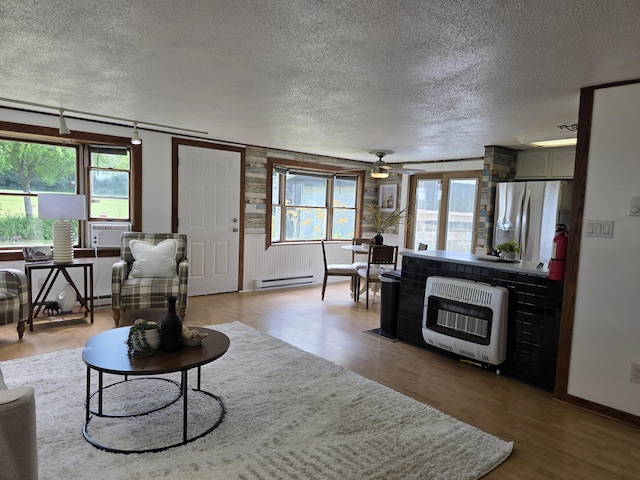 1236 Klink Rd, Tekonsha, MI 49092 - living room featuring heating unit, a textured ceiling, light wood finished floors, ceiling fan, and baseboard heating