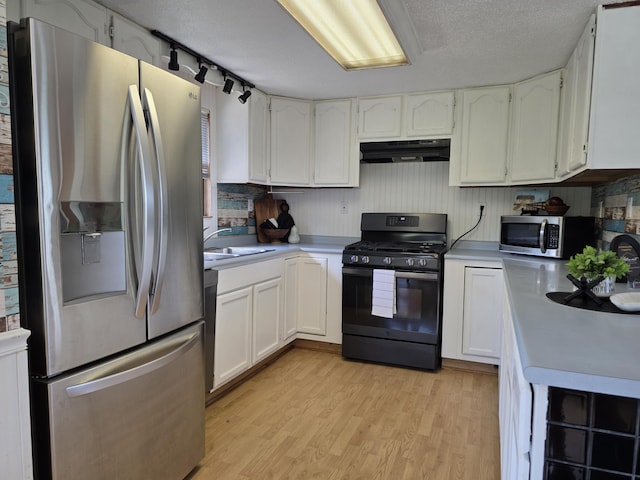 1236 Klink Rd, Tekonsha, MI 49092 - kitchen with appliances with stainless steel finishes, under cabinet range hood, light countertops, light wood-style flooring, and a textured ceiling