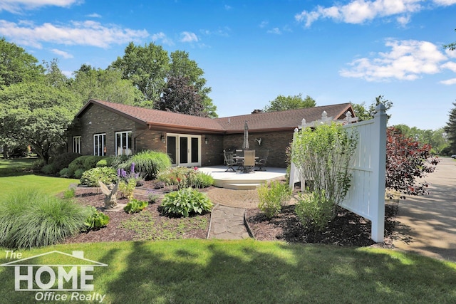2367 Meadowdown Dr, Owosso, MI 48867 - back of property with brick siding, french doors, a patio, and a yard