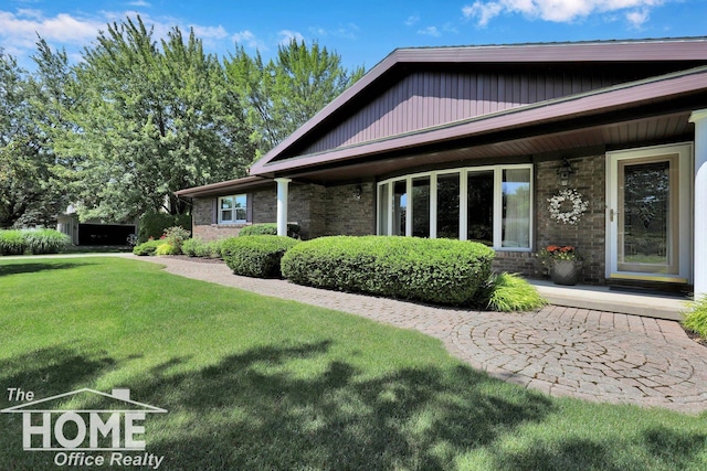 2367 Meadowdown Dr, Owosso, MI 48867 - rear view of property featuring a lawn and brick siding