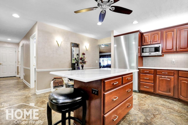 2367 Meadowdown Dr, Owosso, MI 48867 - kitchen with stainless steel appliances, light countertops, a kitchen breakfast bar, backsplash, and recessed lighting