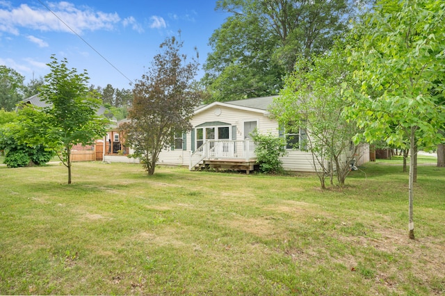 733 N Main St, Evart, MI 49631 - view of front facade featuring a deck and a front yard